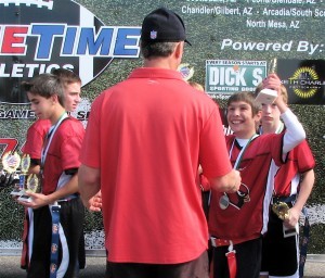 Max holds up his trophies to Coach Tav