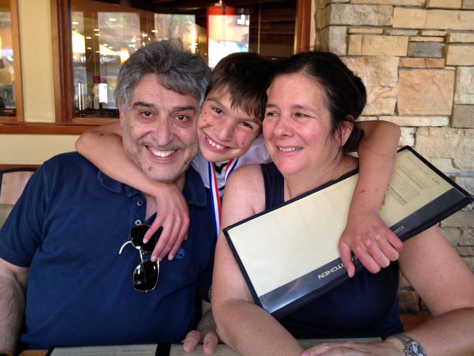 Max hugging his parents at the team party at California Pizza Kitchen